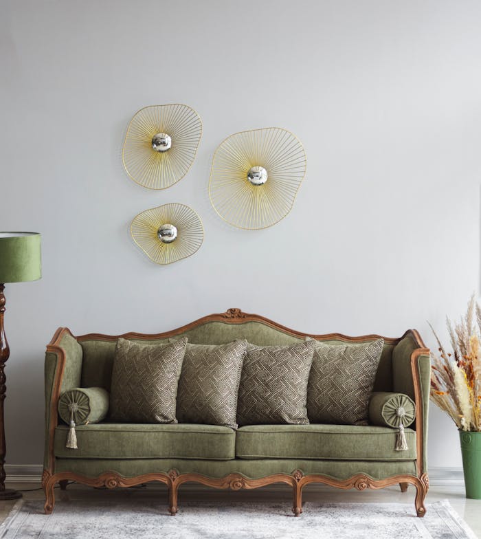 pexels photo 11264910 Vintage green sofa in a stylish living room with artistic wall decor and a floor lamp.