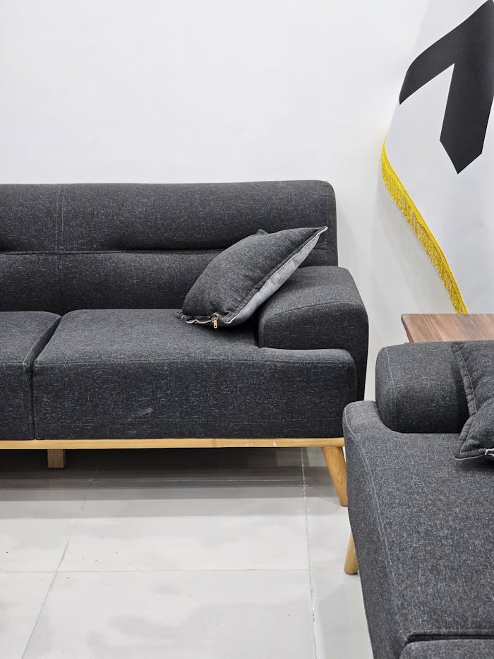 pexels photo 18674014 A minimalist interior featuring a stylish gray sofa with modern decor elements.