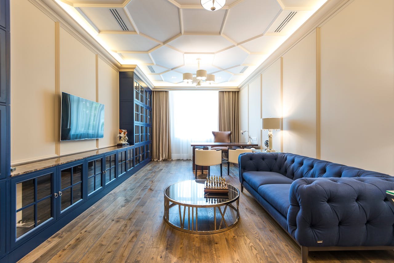 Home A luxurious apartment interior featuring a blue sofa, modern decor, and elegant lighting.
